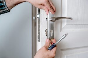 Image of a professional repairing a door hinge.