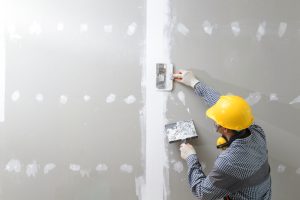 Image of a professional repairing a drywall.