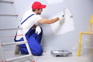 Image of a professional painter applying paint to a wall.
