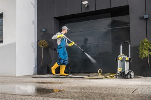  Image of a power washer cleaning a driveway.