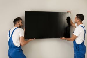 Image of a professional mounting a TV on the wall.